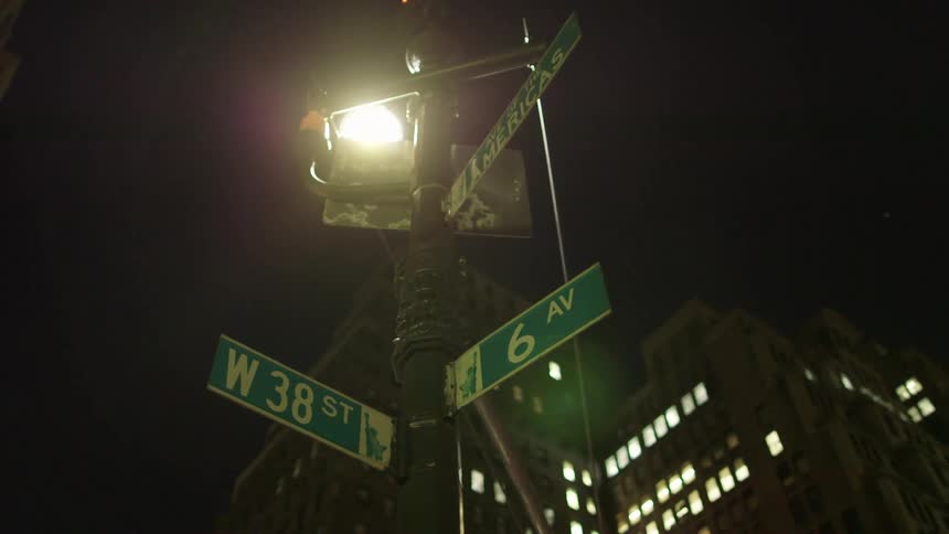 A street sign is illuminated by a light