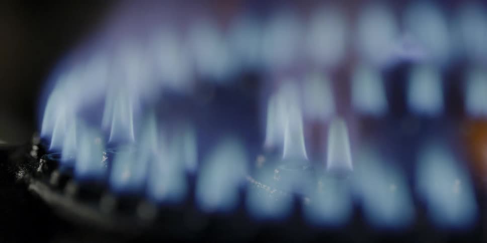 Blue flames rise as a gas stove is turned on