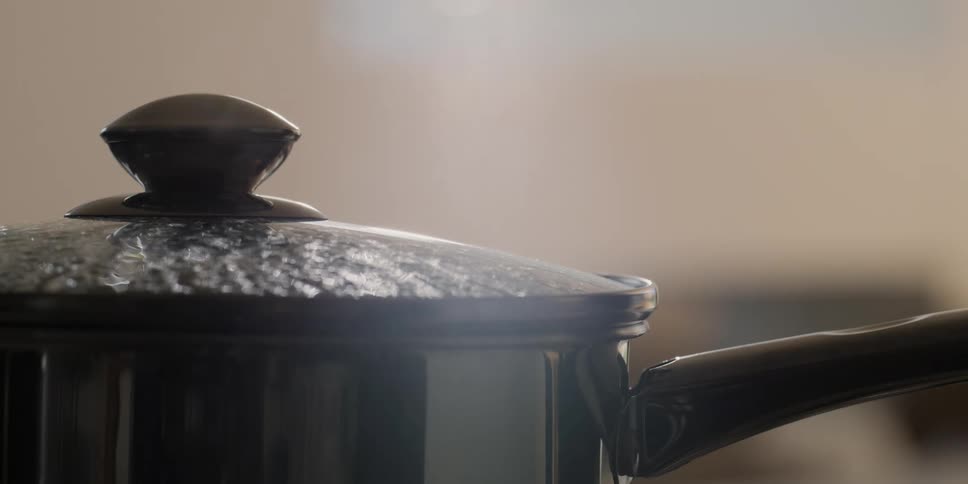 A pot of boiling water on a kitchen
