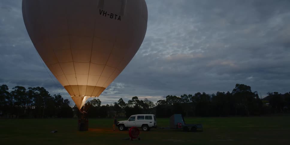 Hot air balloon on a field at sunrise