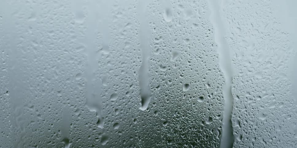 Drops caused by condensation run down foggy glass