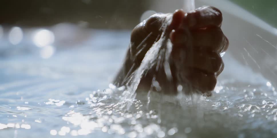 A person washes their hand in the bath