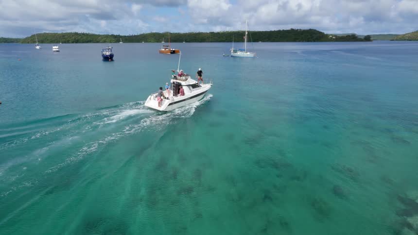 A boat is sailing towards some docked boats in the water