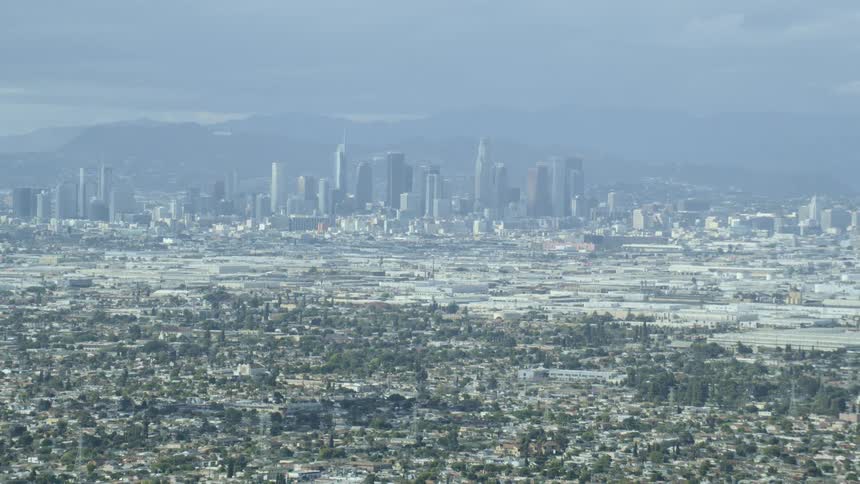 Aerial view of the distant city with tall buildings and skyscrapers during daylight
