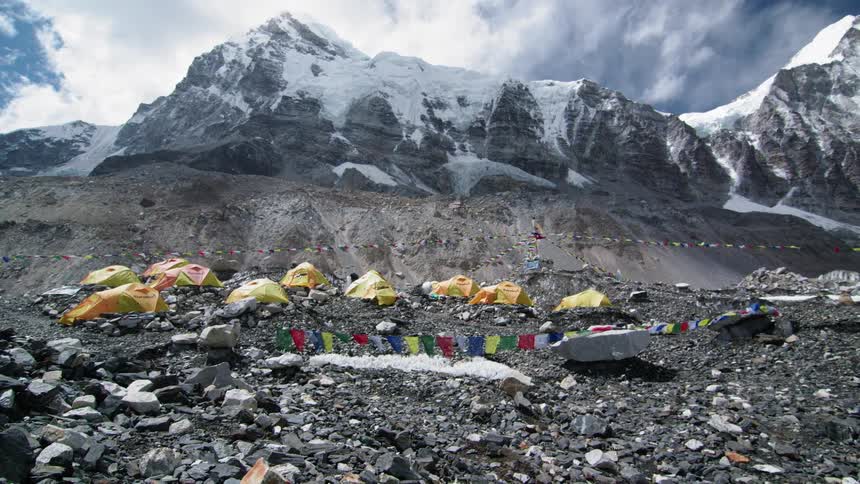 Tents are set up along the slope of a mountain
