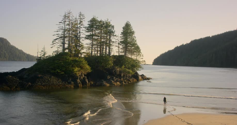 Man walks in the water towards an island