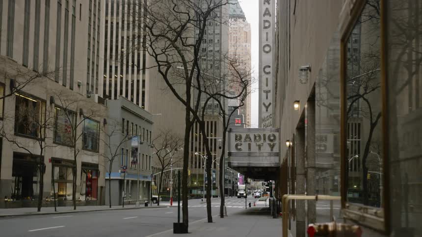A few cars drive down a quiet new york city street