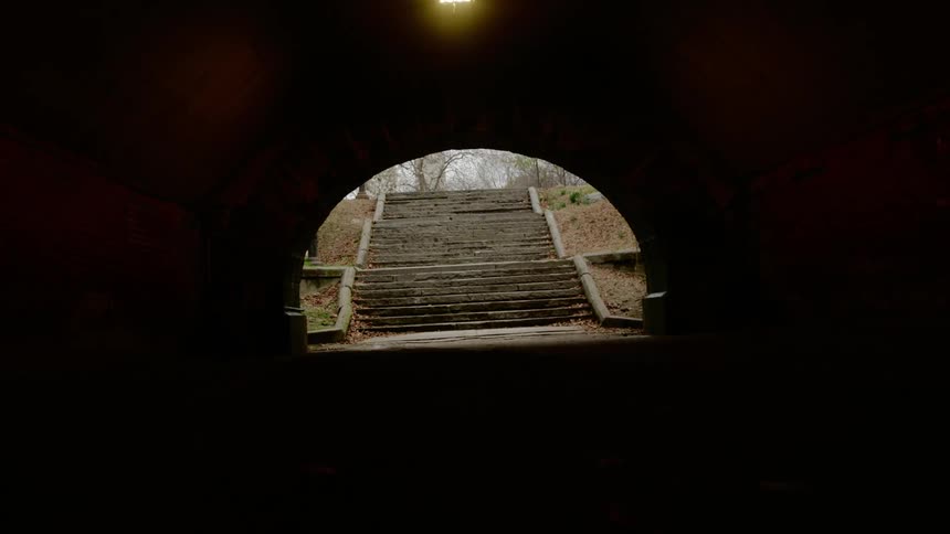The tunnel is dark before the staircase