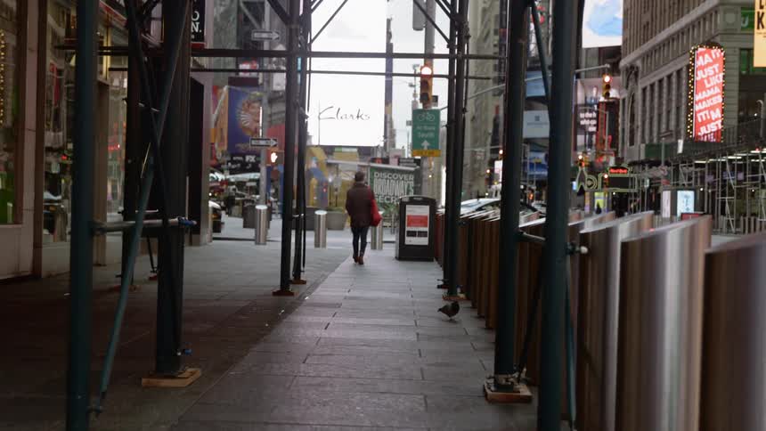 A woman walks down an empty city street
