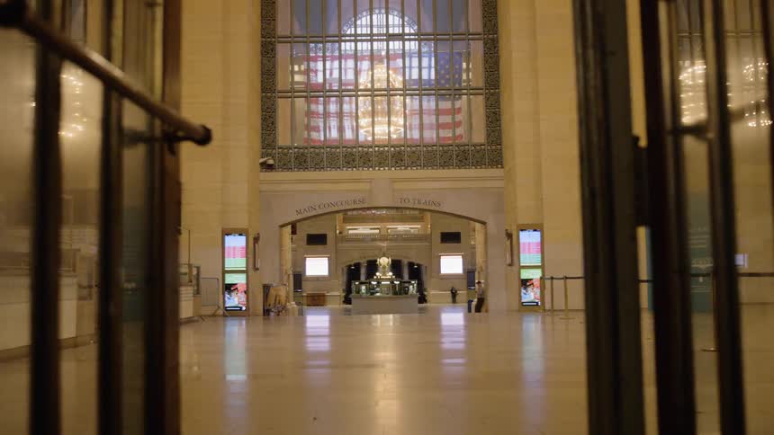 Glass and metal doors stand open to the interior of a large building