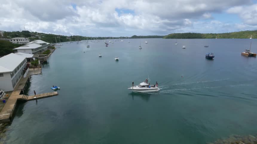 A boat pulls into a small dock on a cloudy day