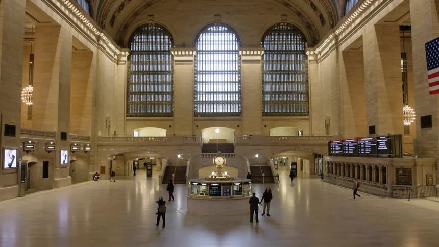 People walk through an almost empty train station