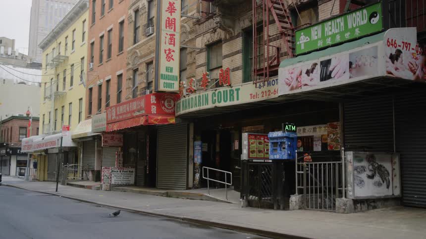 Car drives past empty sidewalks and shops