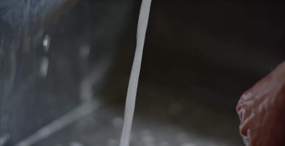 A person washes their hands in a sink