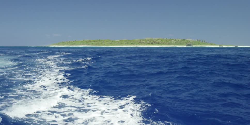 An island can be seen past blue water on a sunny day