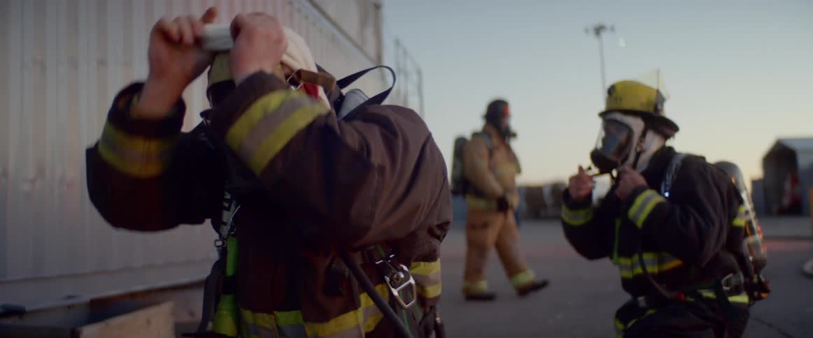 Firefighters wears protective fireman clothes on the scene of accident at dusk