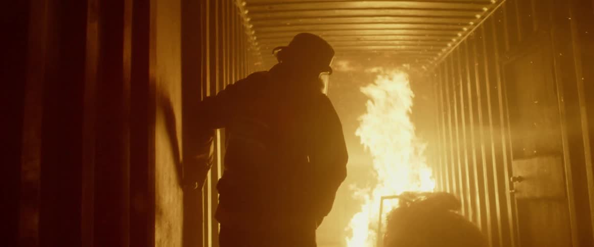 Firefighter closes door on container with fire inside