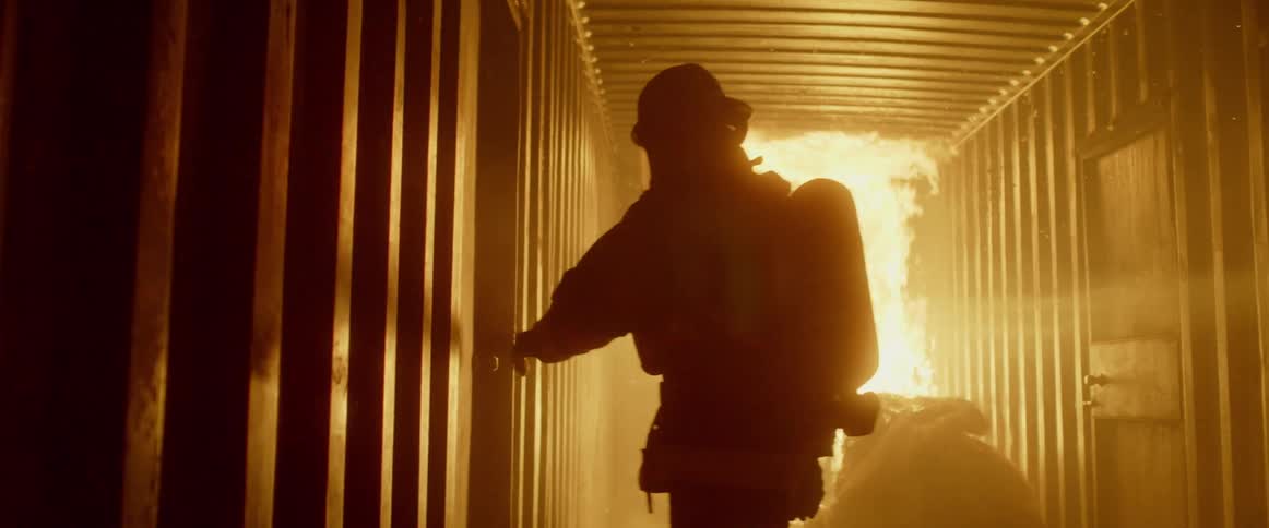 A fireman walks toward a fire