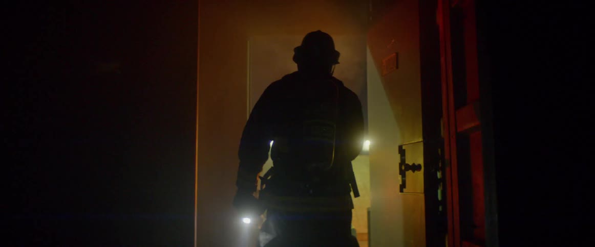 A firefighter walks into the room