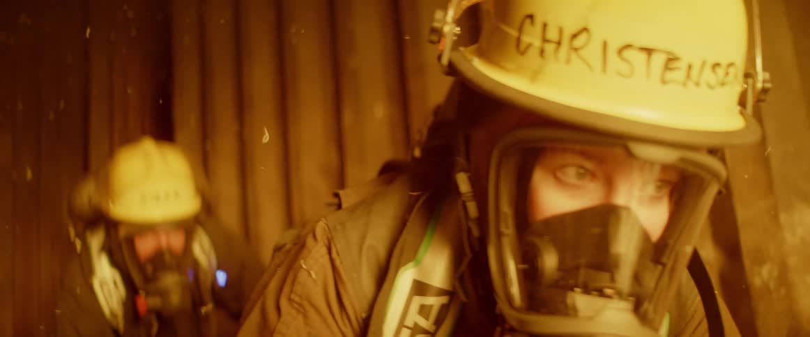Two firefighters are crawling in a building