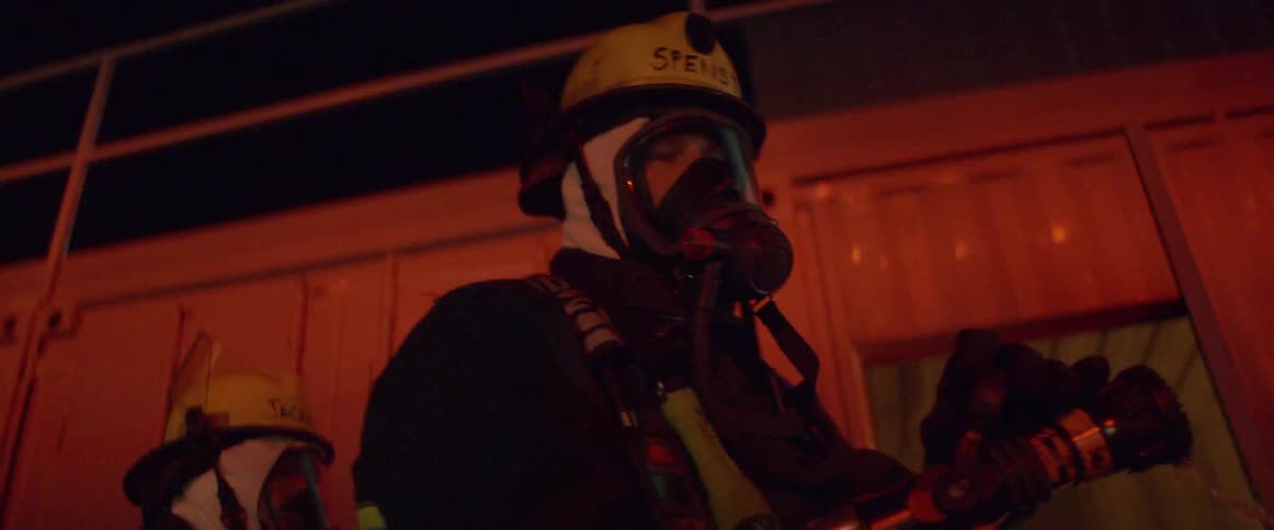 Firefighters standing and looking around with lights flashing