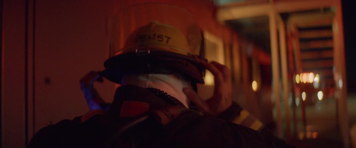 A firefighter puts his helmet on