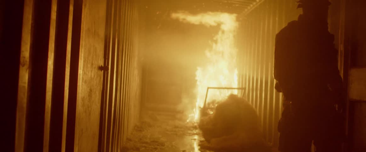 A firefighter walks down the dark hall