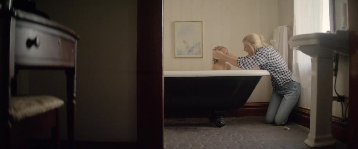 A mother gives her daughter a bath