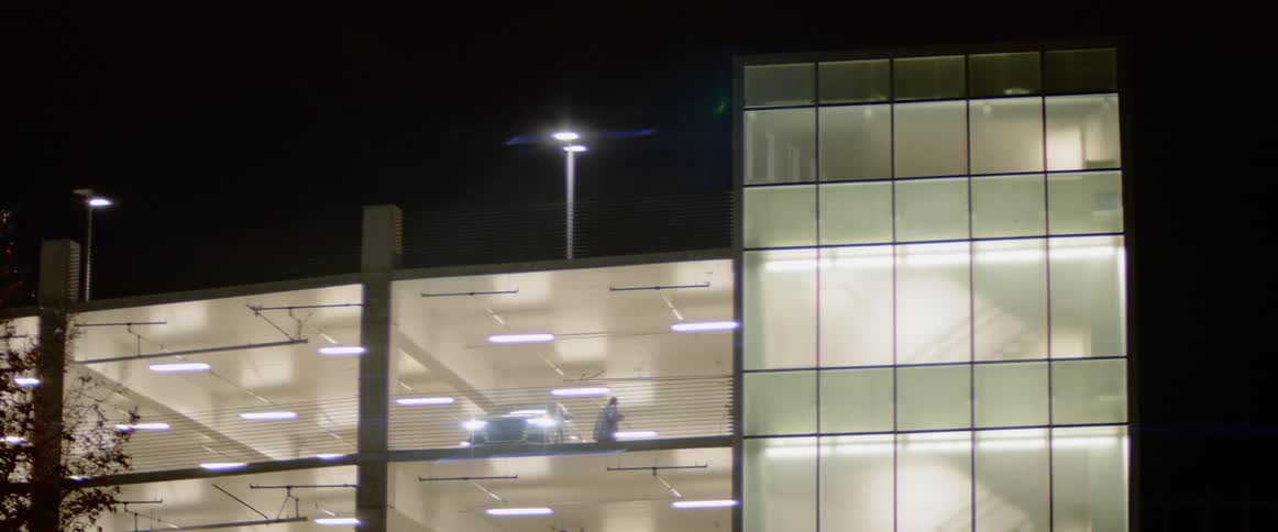 A person parking their car in an extremely well lit parking lot