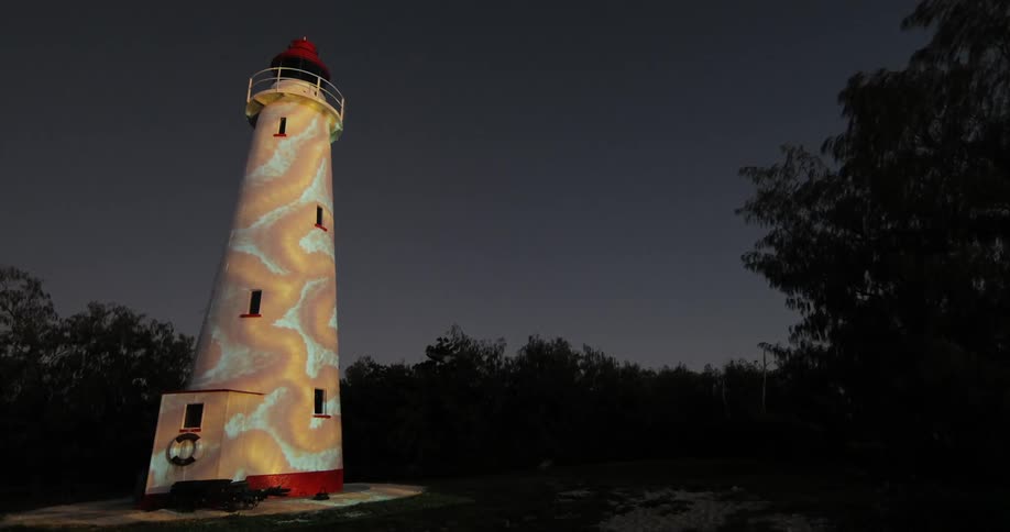 A light tower sits on a field at night