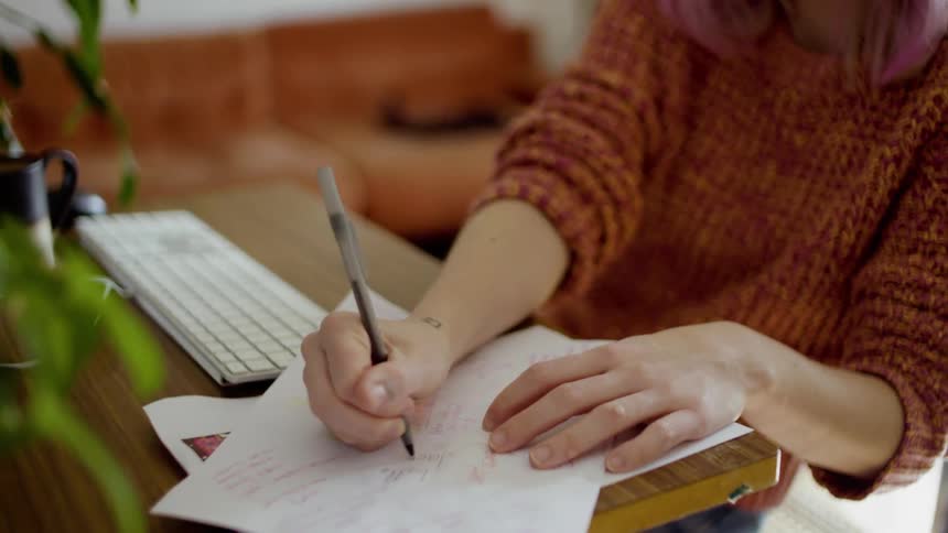 A woman writes notes down on a paper