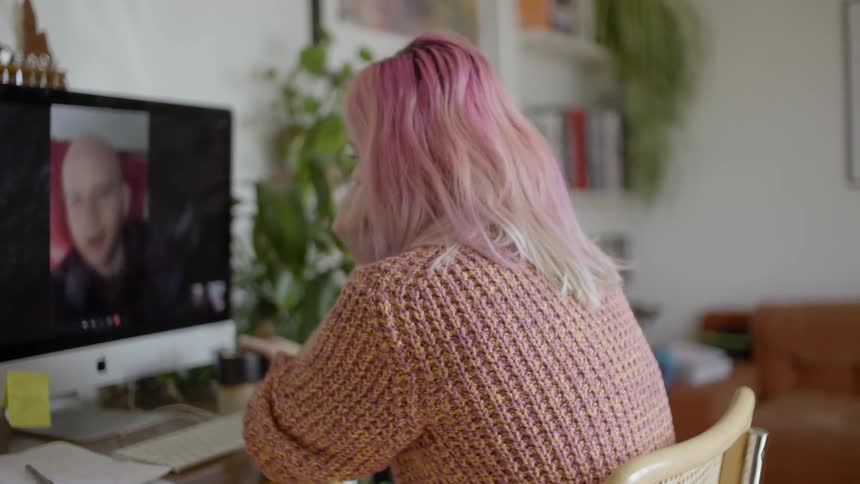 A woman is video chatting with a someone on her computer