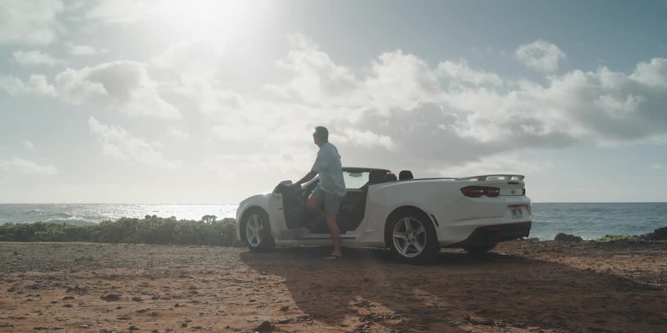 A couple get out of their car by the beach