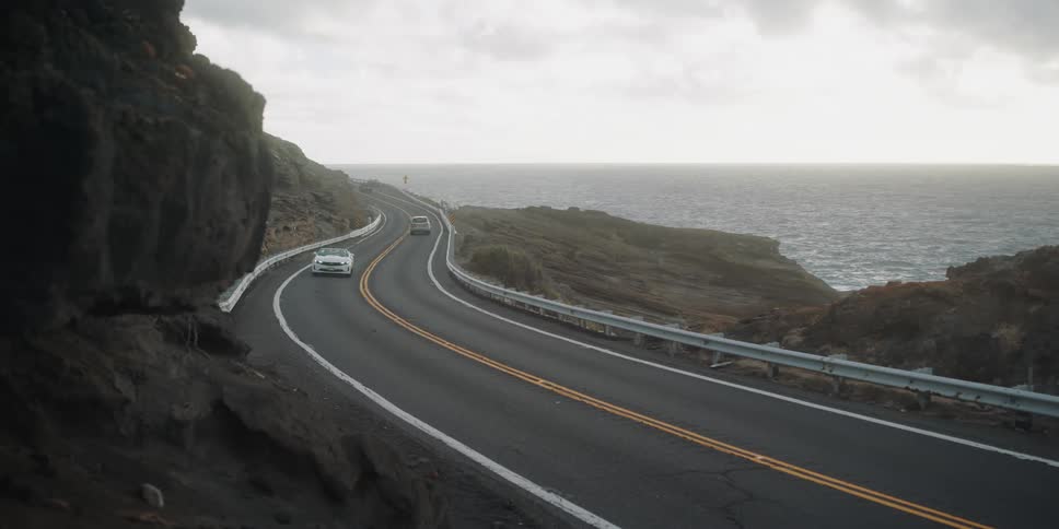 Cars drive down a mountainside road
