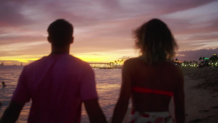 A couple walks along the beach