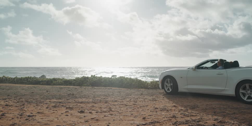 A man pulls his car up to the shore