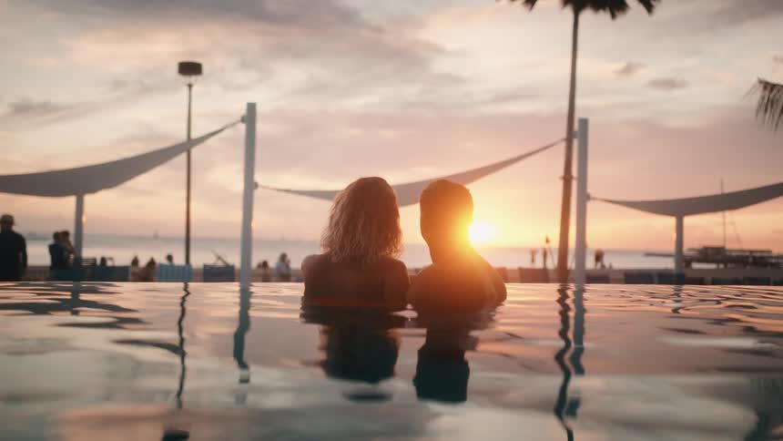 A man and woman relax in a swimming pool