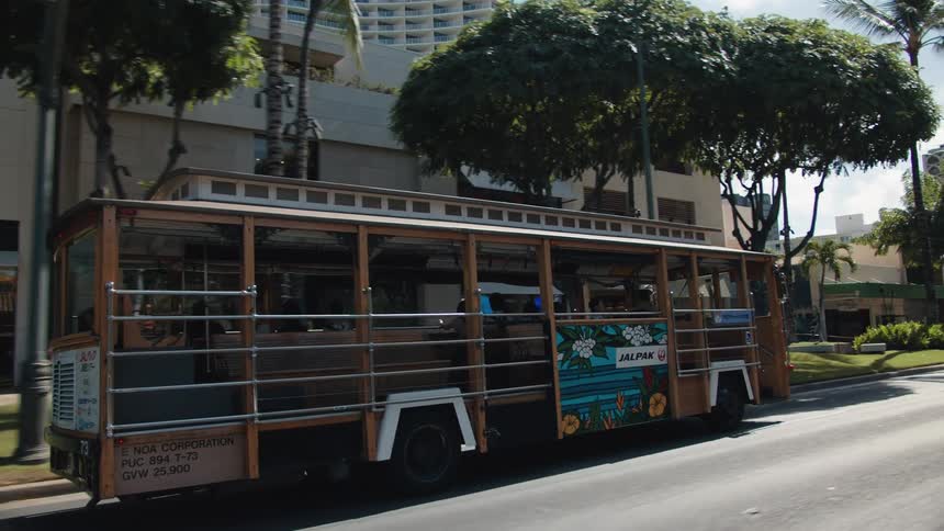 A public transit trolley travels down a city street