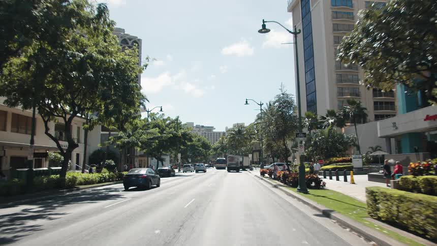 Cars driving on city downtown street at day