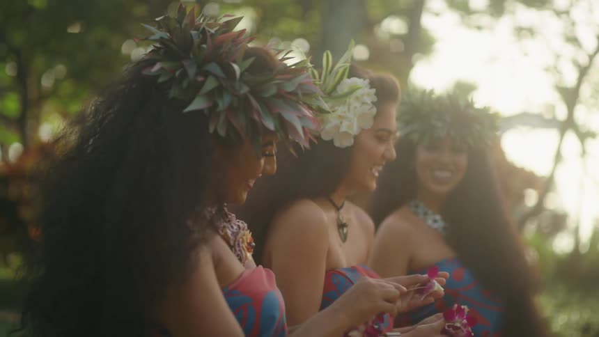 Three women make hawaii flower necklace together