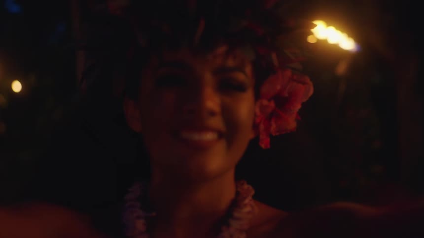 Beautiful hawaiian woman placing a flower lei on you at a luau