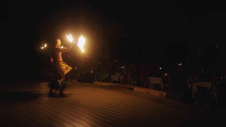 A dancer twirling a staff with fire burning on either end