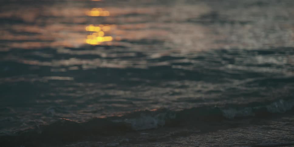Sun setting over the ocean between clouds
