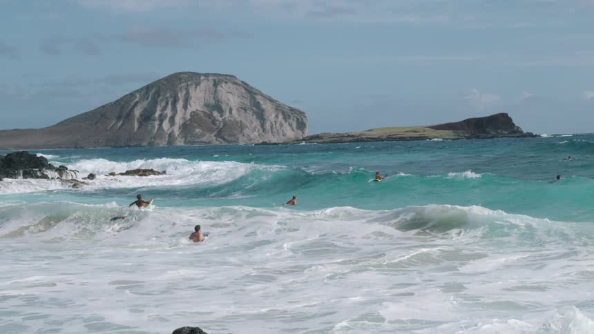 A group of people are surfing in the ocean waves