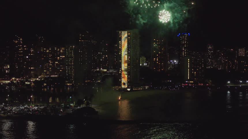 Fireworks light up the night sky outside of a large city