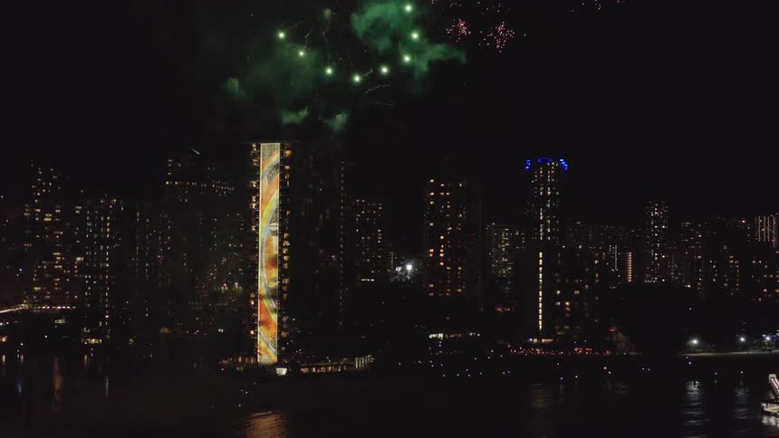 The fireworks explode around the buildings ahead
