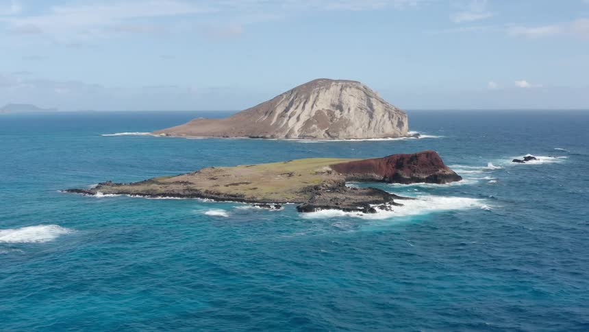 Ocean waves break against the small rocky island