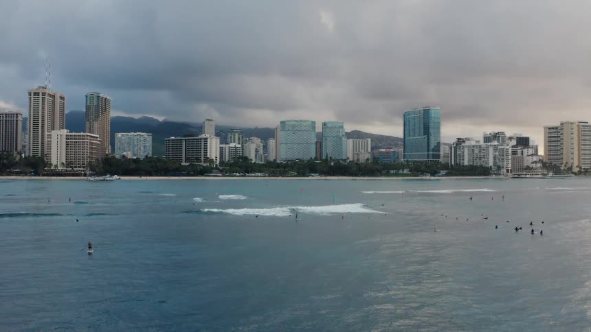 People playing in the tide off the coast of a metropolis