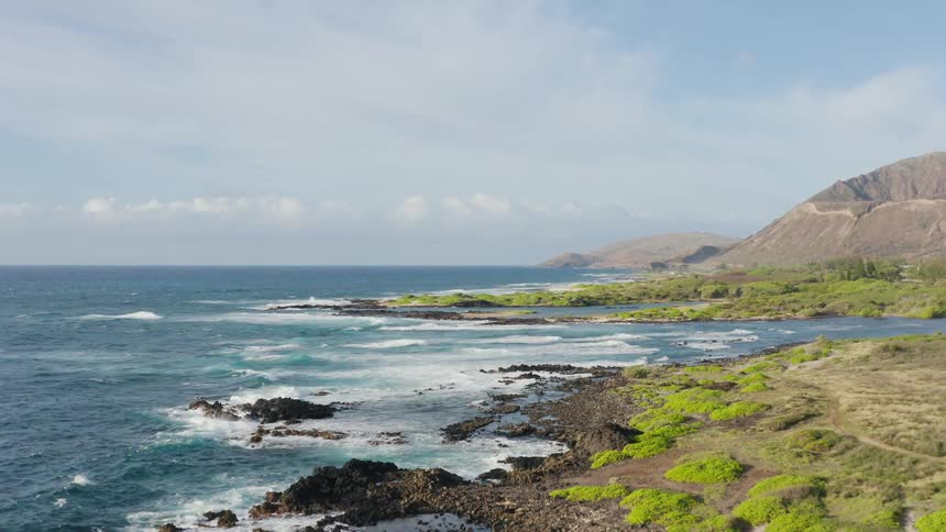 Aerial view of sea waves crashing against rocky shore
