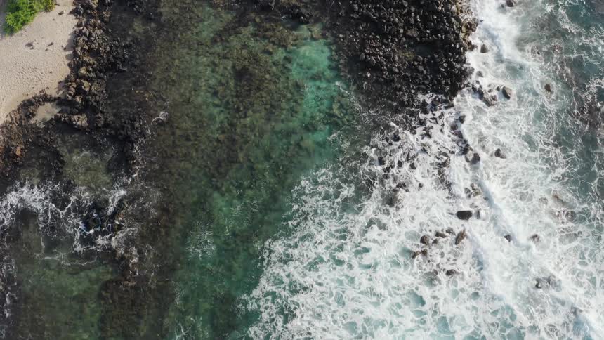 Birds eye view of waves crashing in to the shore